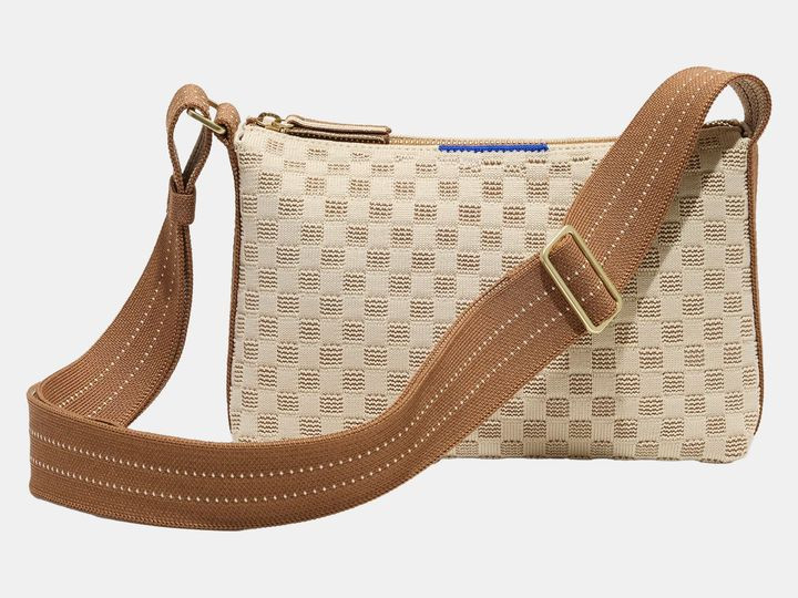 Rothy's The Casual Crossbody bag in beige and brown strap.