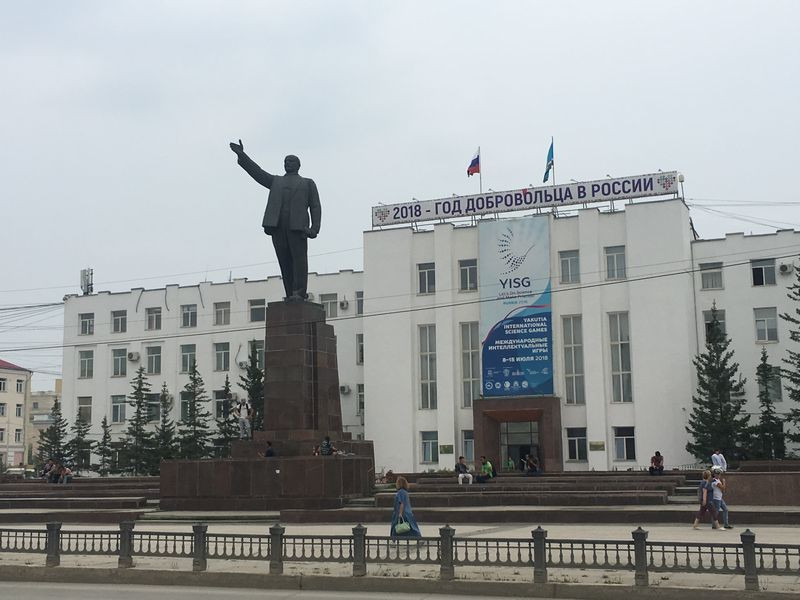 Yakutsk Yakutia Russia: Tourists taking pictures on the snow-covered Lenin Square, featuring a statue of Lenin.