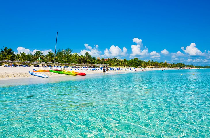 A panoramic view of Varadero beach, highlighting its white sand, turquoise waters, and palm-fringed resorts