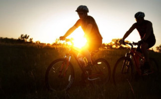 Cyclists riding through the Flint Hills during sunset, enjoying the scenic views and open roads