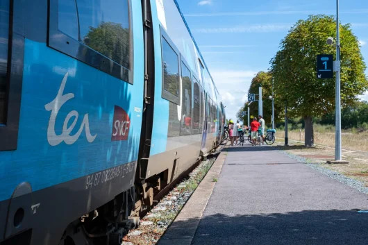Cyclotouristes et train à quai en gare de Pontorson-Mont-Saint-Michel