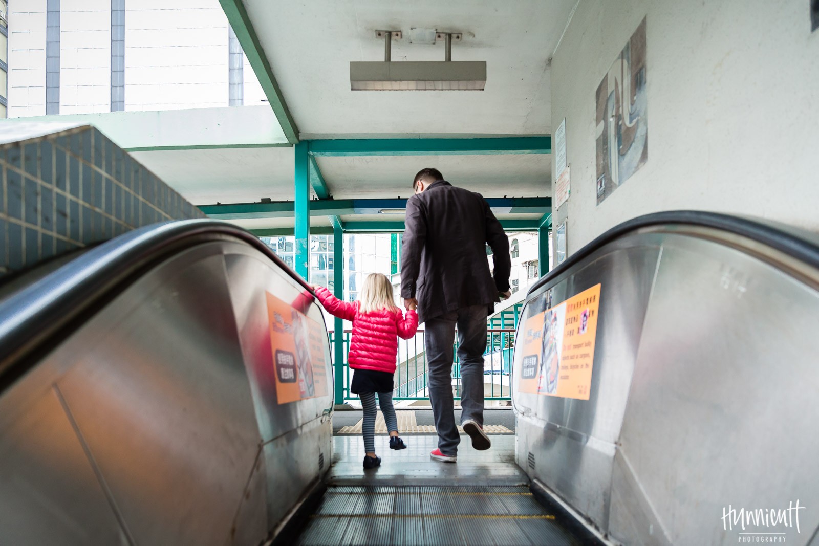 Dad and daughter on escalator in Hong Kong By Rebecca Hunnicutt Farren