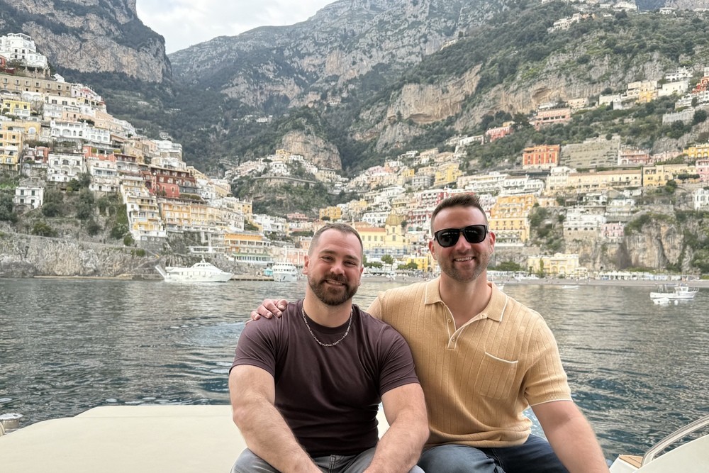 Travelers exploring the Amalfi Coast by private yacht in Italy, with Positano in the background.