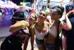 Tourists react as they pose for a photo at the resort of Magaluf, in Calvia town, on the Spanish Balearic island of Mallorca, June 10, 2015