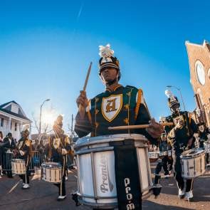 Band playing lively music on a street during a vibrant Mardi Gras celebration