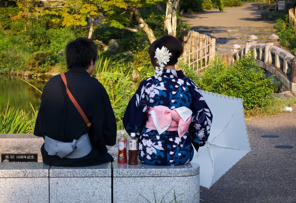 A solo female traveler enjoying a peaceful moment in a traditional Japanese garden in Tokyo, showcasing the serenity and safety of exploring cultural sites