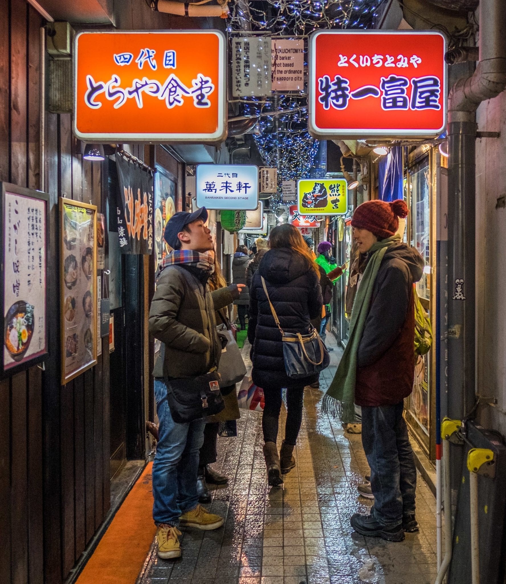 A bustling street scene in Tokyo at night, showcasing the city's vibrant yet safe atmosphere