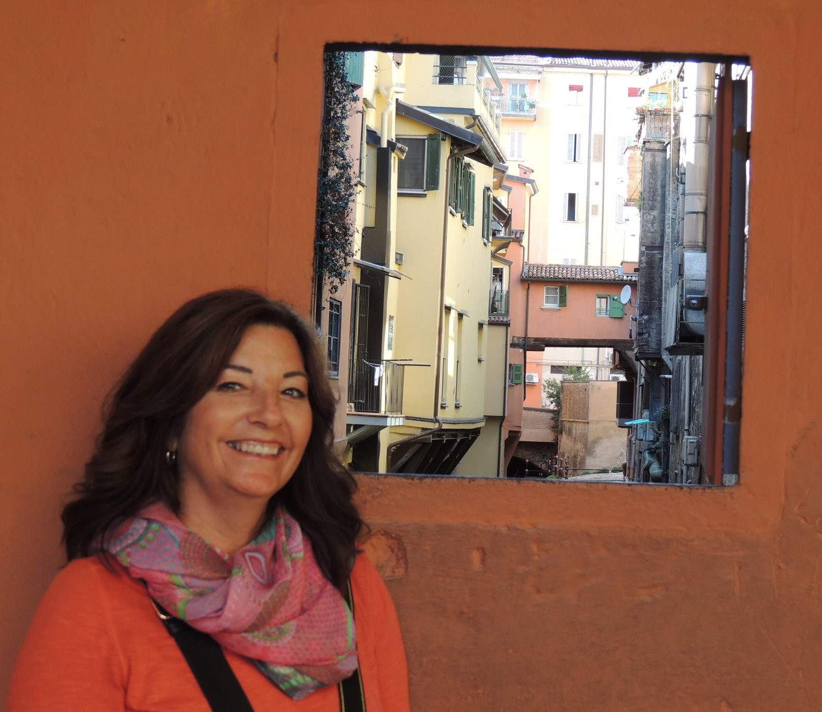 Woman wearing a scarf in Bologna, Italy, highlighting a versatile travel accessory.