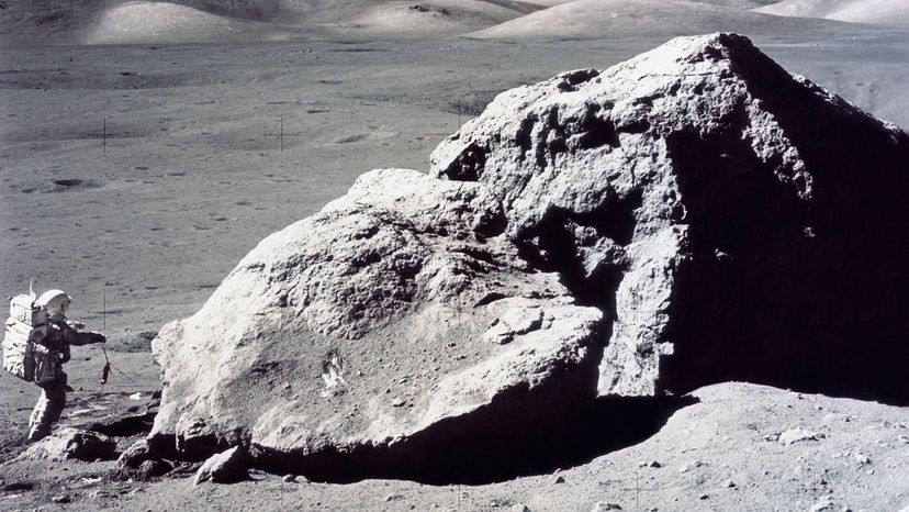 Apollo 17 astronaut collecting moon rock samples, showcasing the lunar surface and the astronaut's equipment