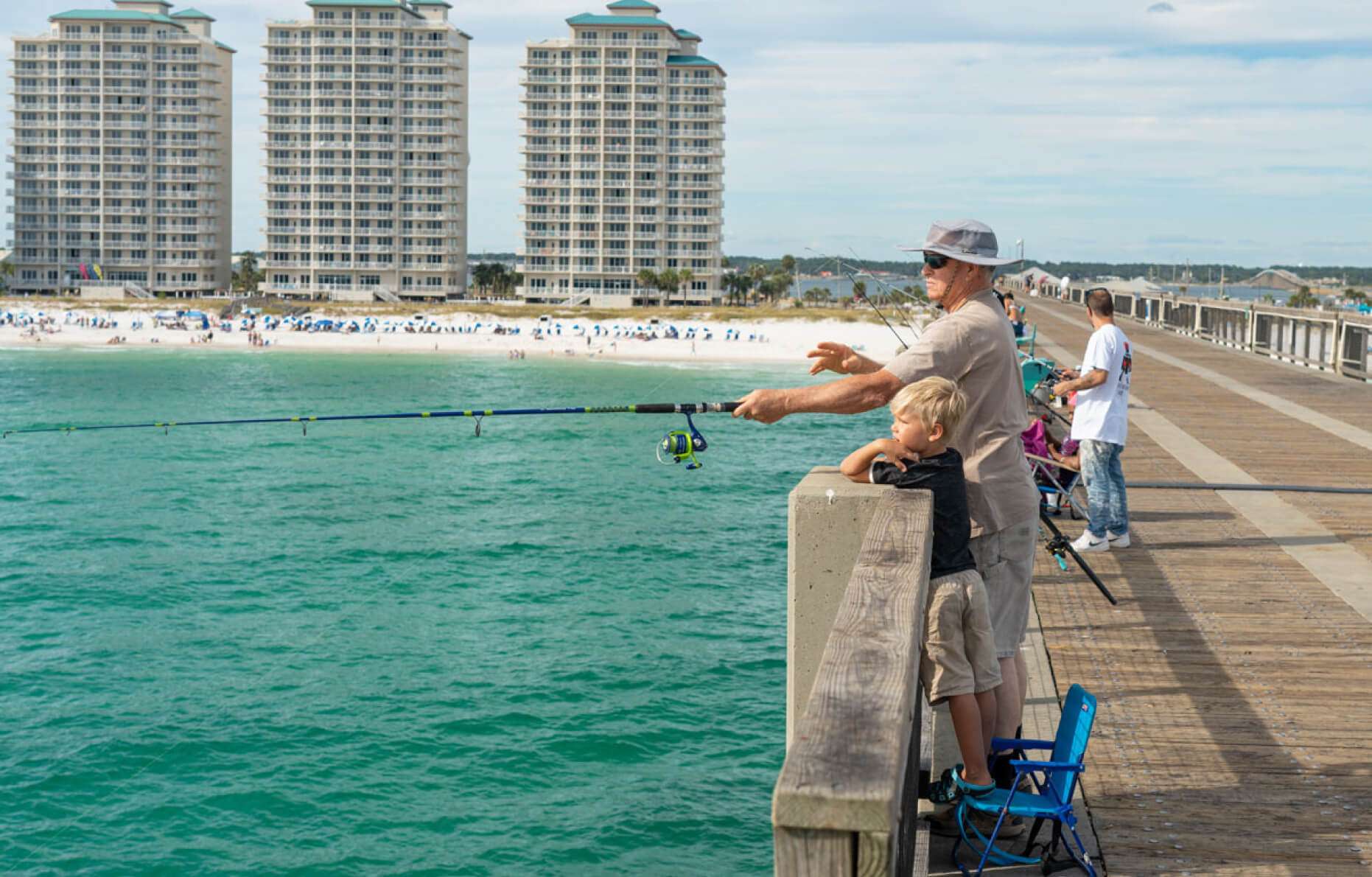Angler casting a fishing line into the water at Navarre Beach, Florida, with the sun setting in the background