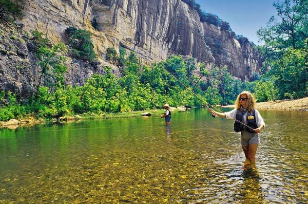 Two people fly fishing in the Buffalo River in Arkansas.