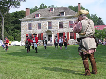 Fort Johnson historic site in Amsterdam, NY, featuring a large stone house with a green lawn in front