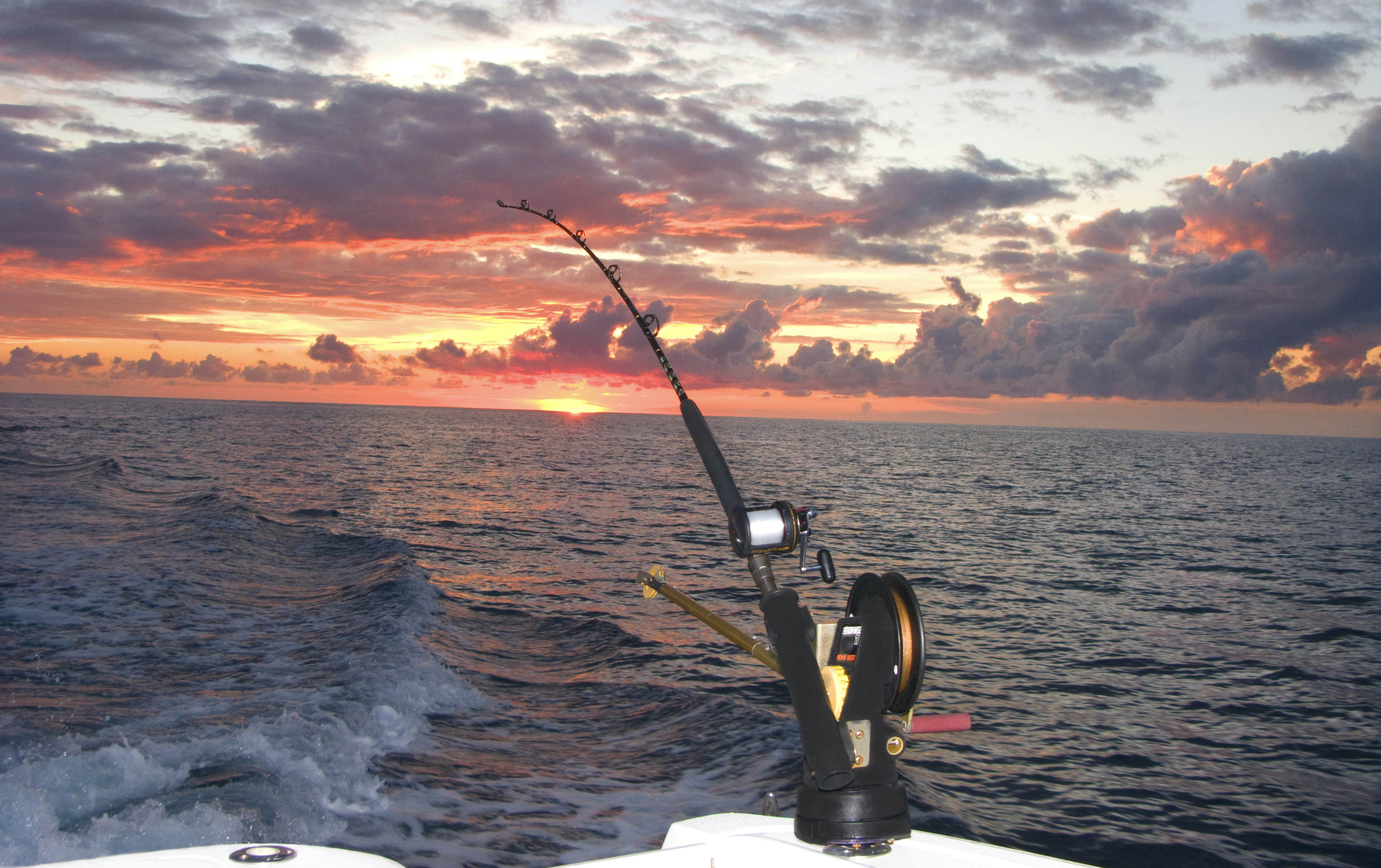 Fishing pole with downrigger trolling at sunset, Bimini, Bahamas