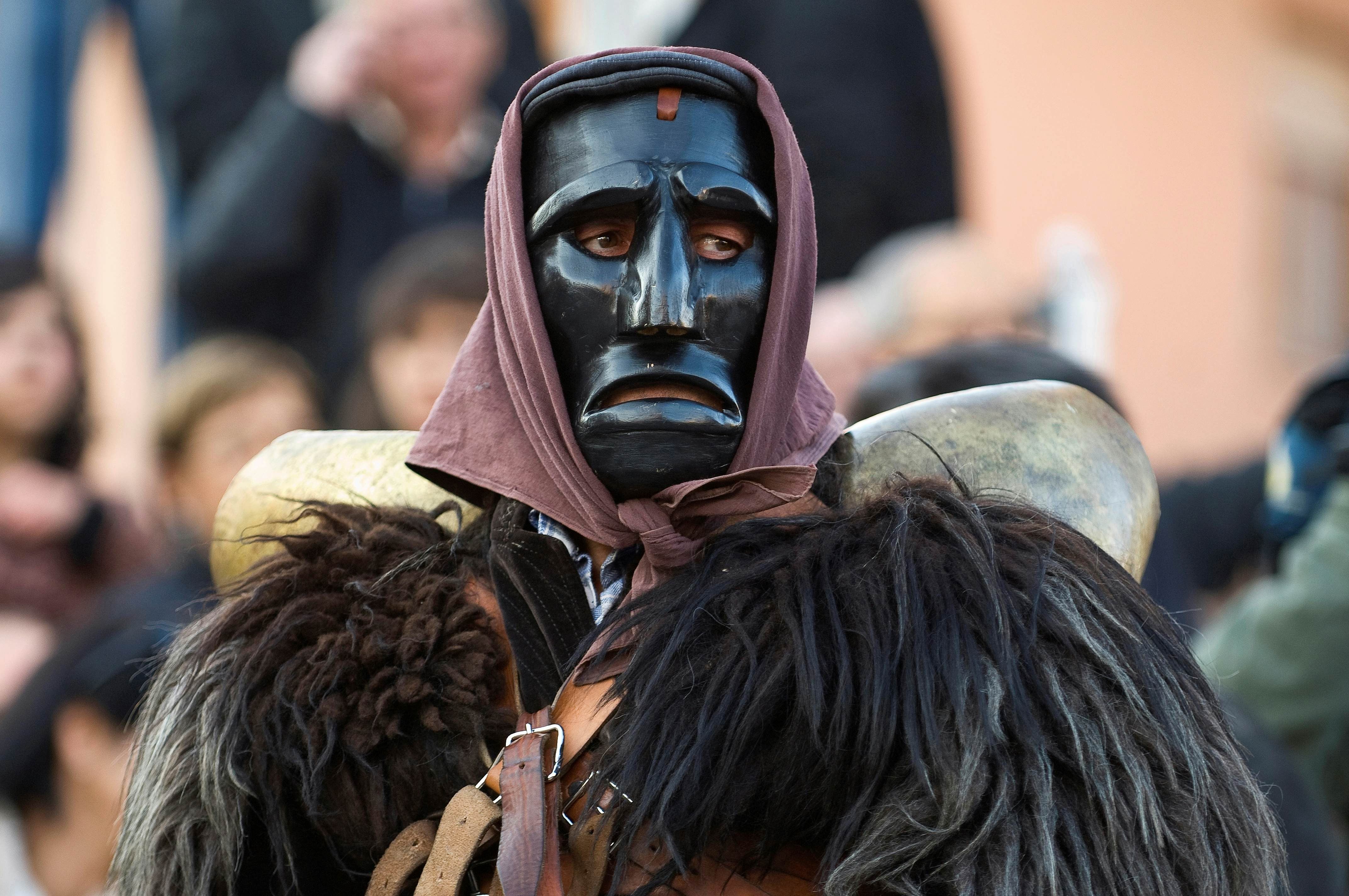 Costumed, masked ”mamuthones,” men clad in hand-carved black masks and shaggy sheepskins, Mamoiada, Sardinia, Italy.