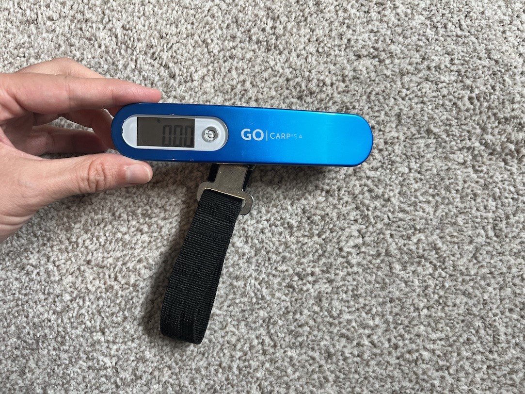 A blue digital luggage scale