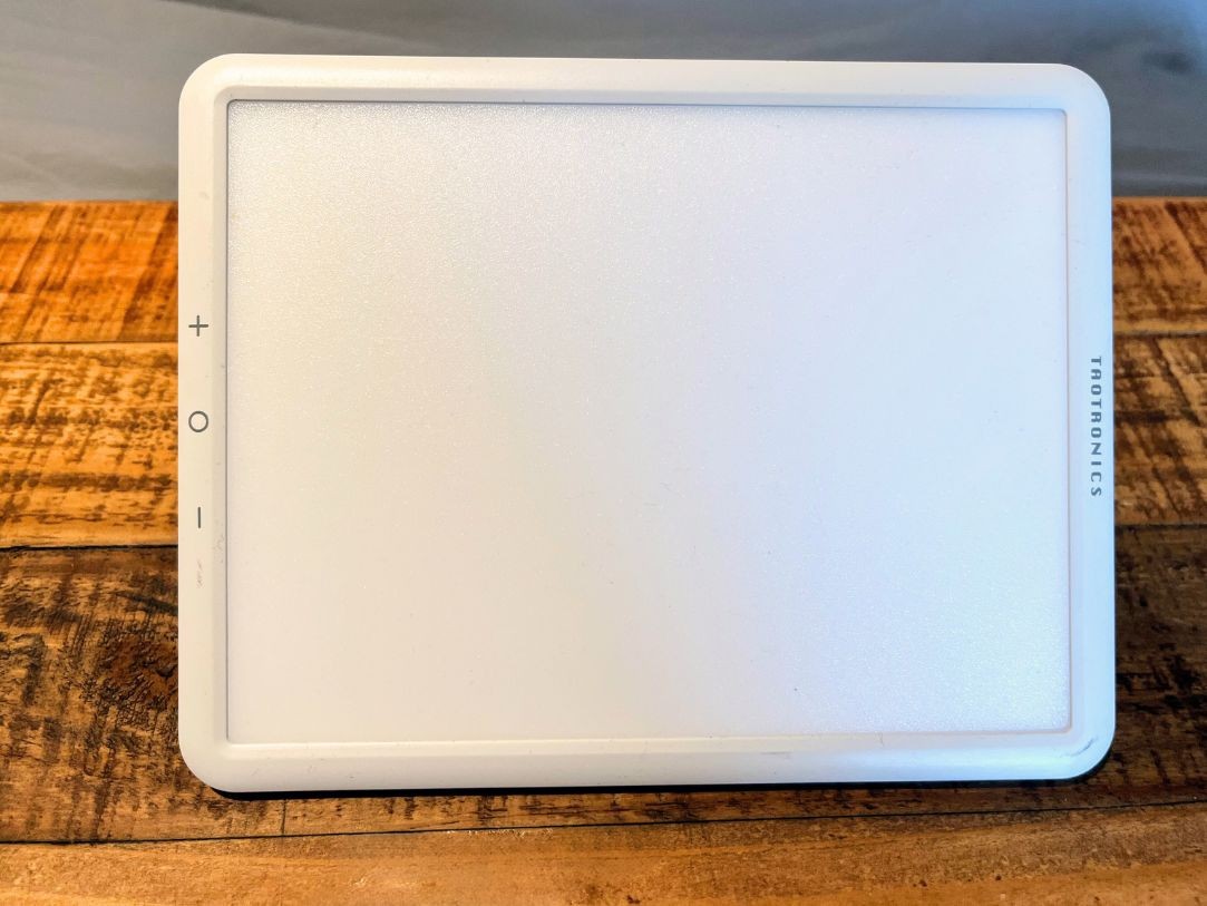 A light therapy lamp on a bedside desk
