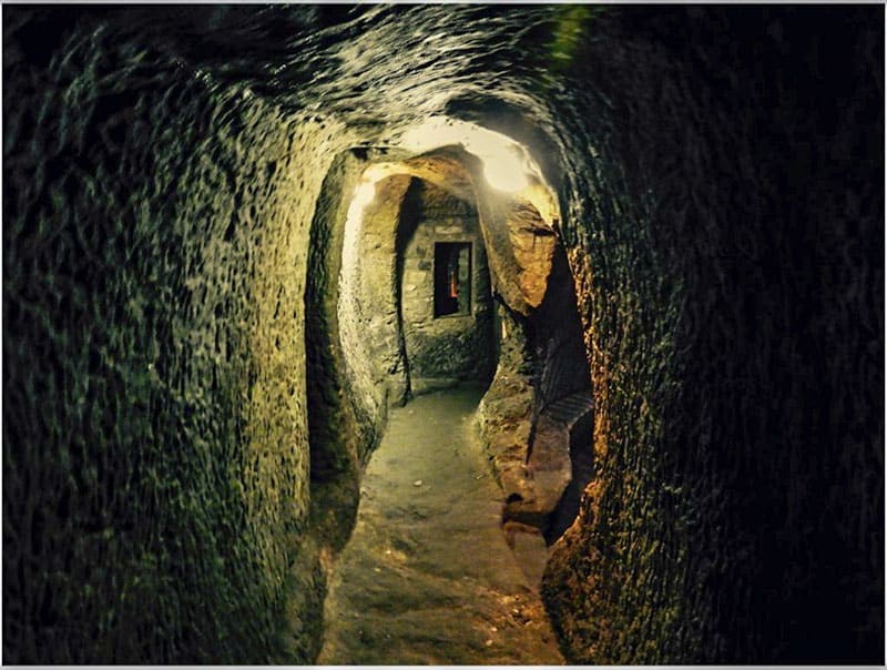 The dimly lit interior of Gilmerton Cove, revealing the mysterious hand-carved tunnels and chambers beneath Edinburgh, captivating visitors with its historical intrigue.