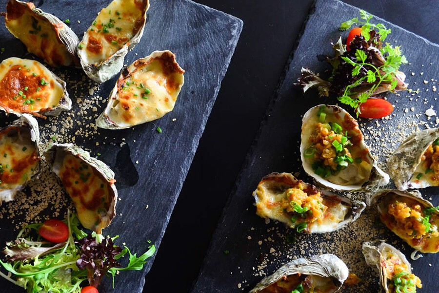 Grilled Oysters (Hau Nuong), a popular and nutritious seafood dish enjoyed with salt, pepper, and lime