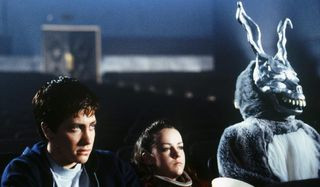 Jake Gyllenhaal and Jena Malone sit close together in Donnie Darko, a still showing the film's young protagonists