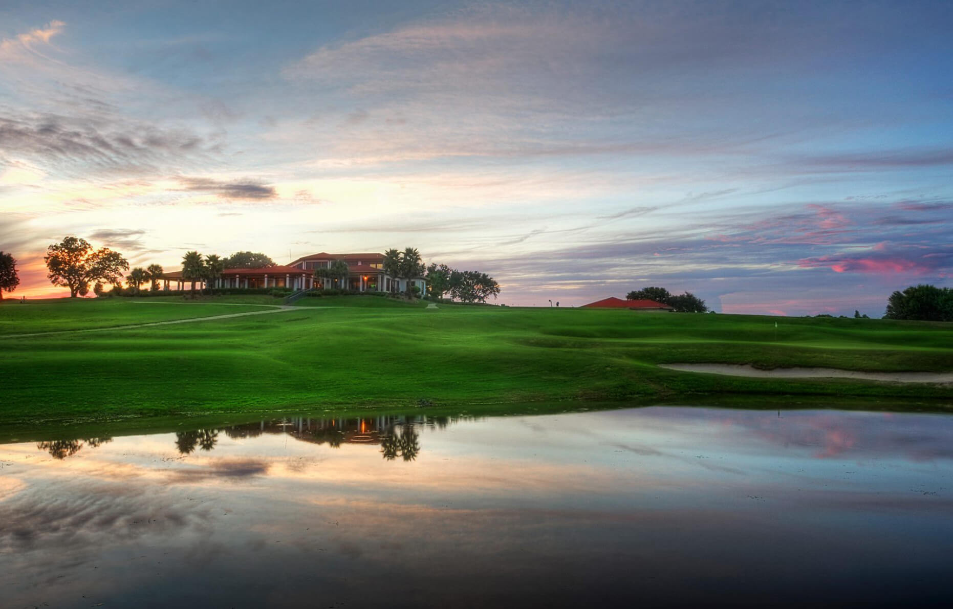 Golfer teeing off on a lush green golf course near Navarre Beach, Florida, with scenic views