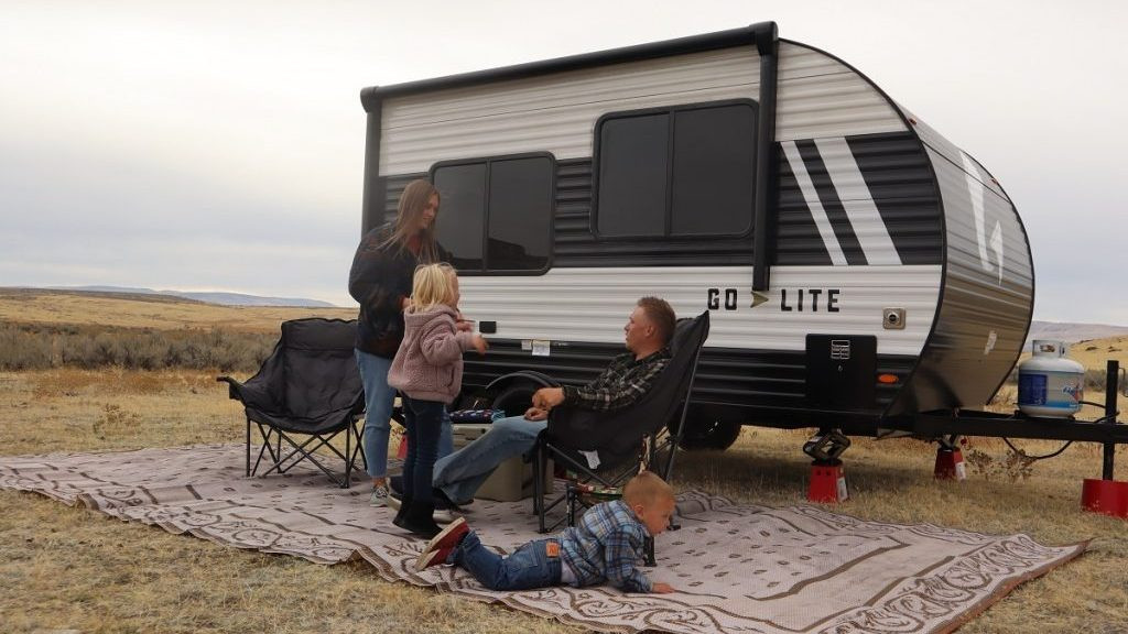 Family enjoying their camping trip with a small travel trailer
