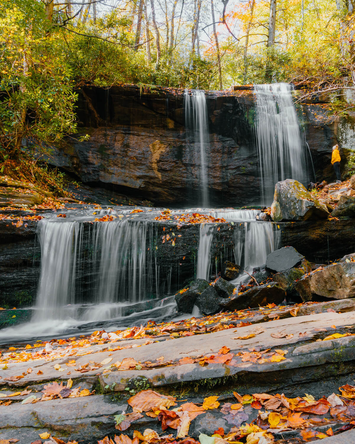 Woman standing in front of Grassy Creek Falls in Little Switzerland, NC