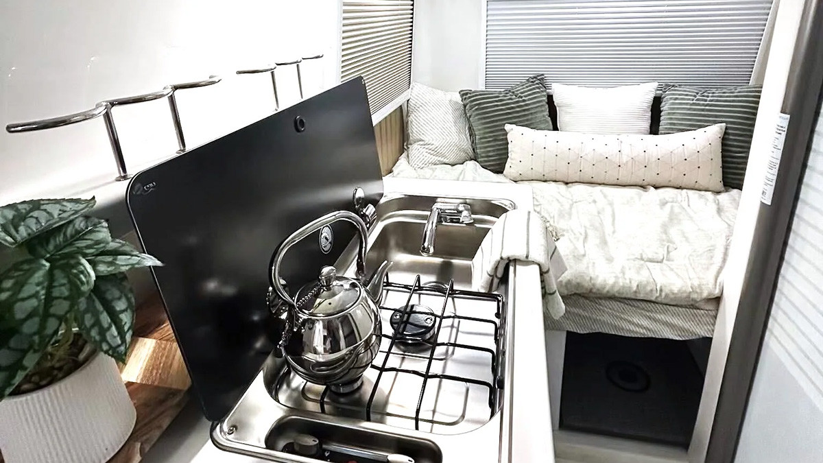 The kitchenette features a built-in stove and stainless steel sink