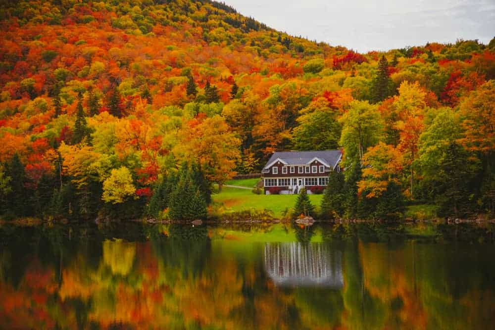 House by a Lake in New England reflecting autumn colors