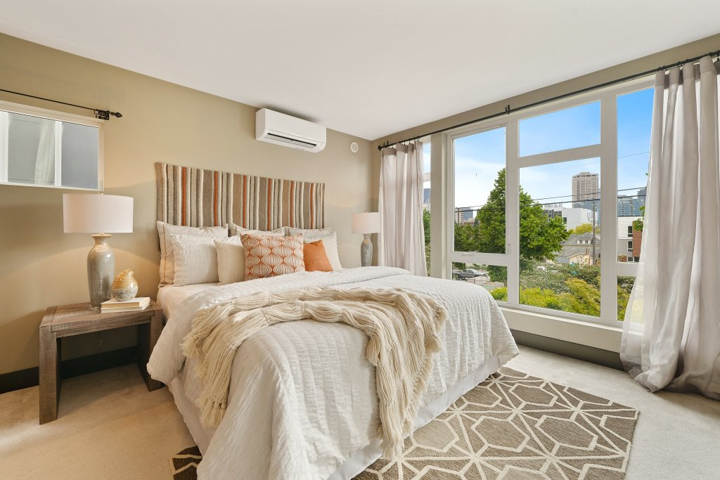 Comfortable bedroom setup with a queen-sized bed, soft lighting, and a small workspace