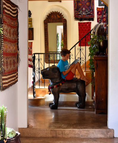A solid wood lion from Bali, adding an exotic touch to the interior design, exemplifying the India World Traveler Collection's adventurous spirit