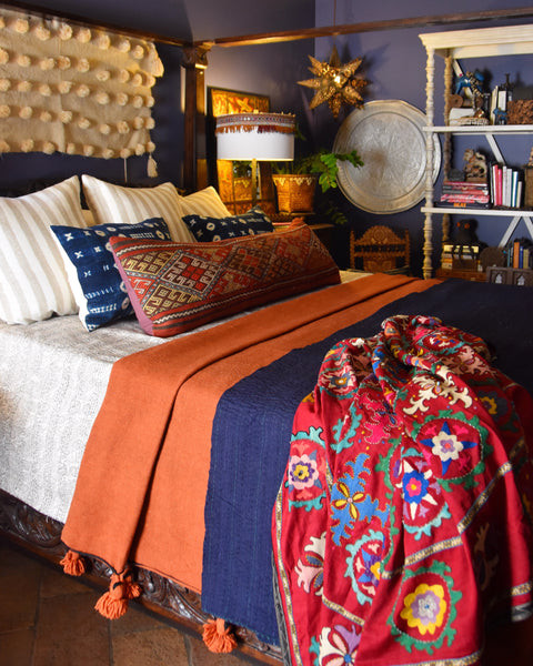 Primary bedroom filled with a revolving assortment of textiles, capturing the essence of the India World Traveler Collection's dark, moody escape