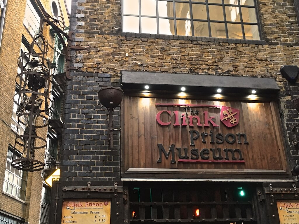 A fake skeleton in a cage hanging outside the Clink Museum