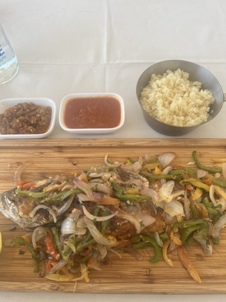 Ivorian dish of grilled fish and attieke with tomato sauce