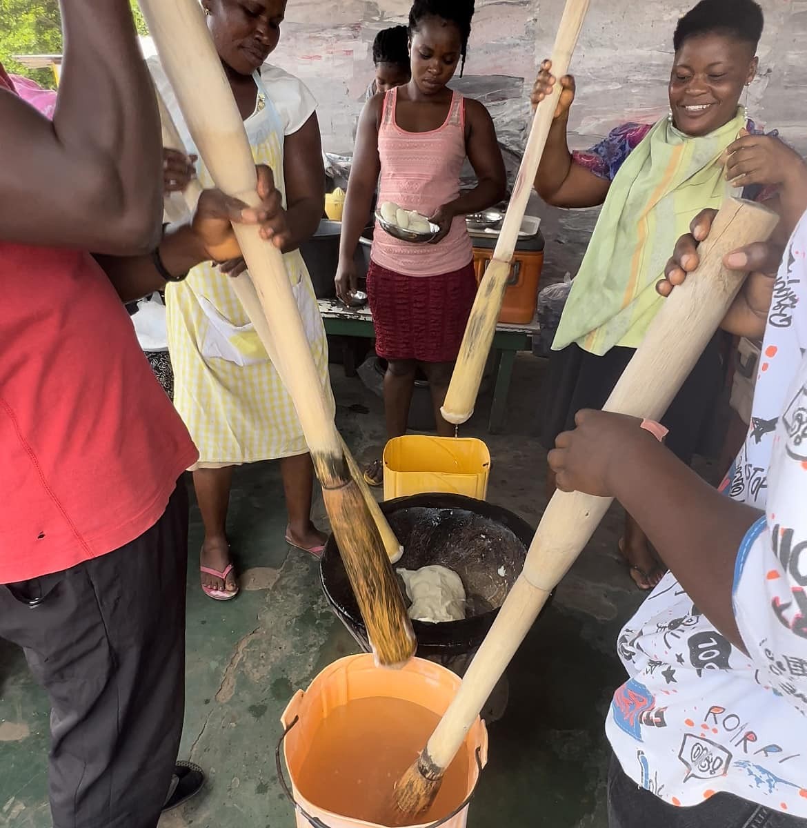 Women pounding fufu at a fufu bar, creating this traditional dish for customers