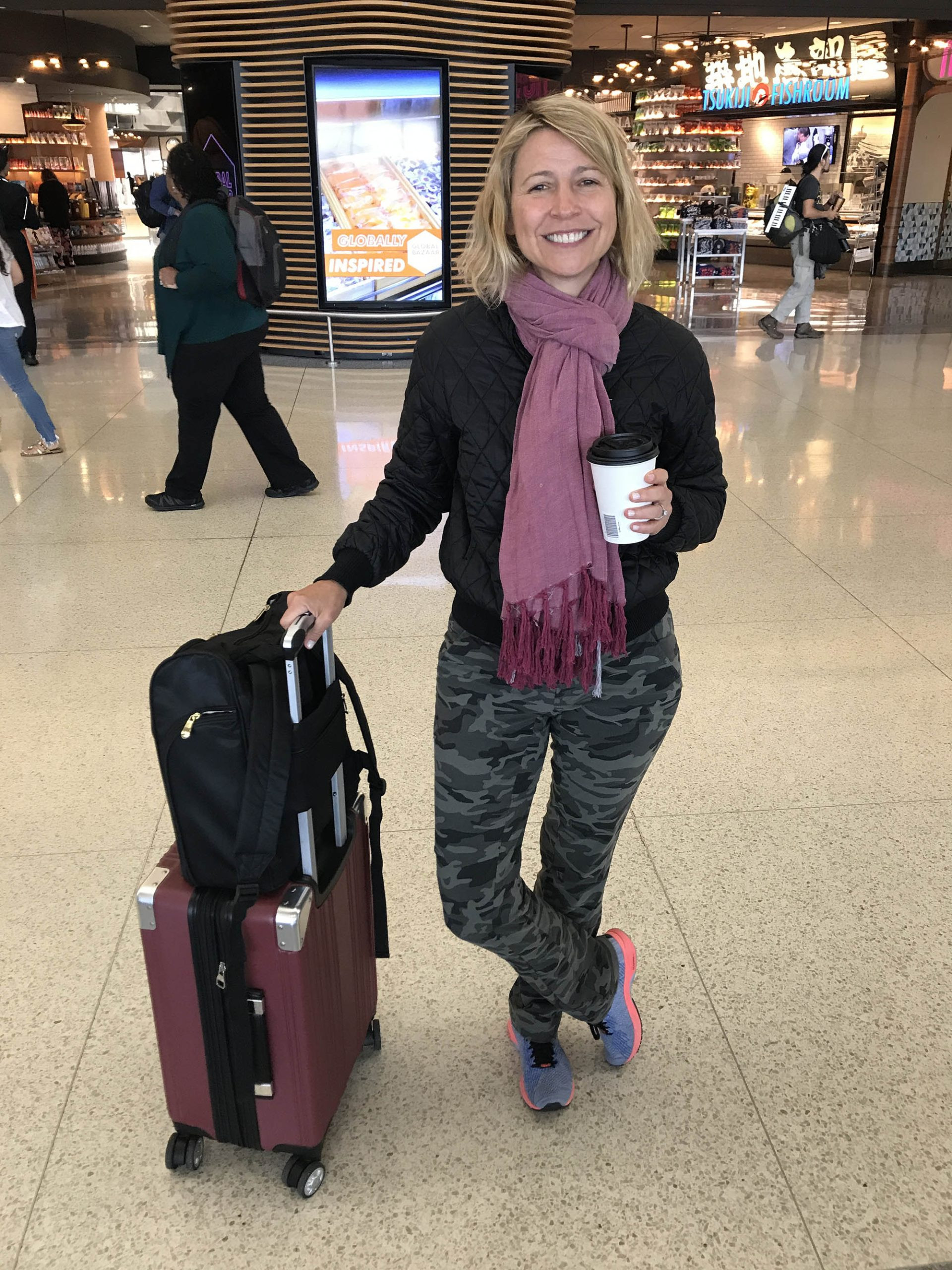 Traveler packing clothes efficiently into a suitcase using rolling method