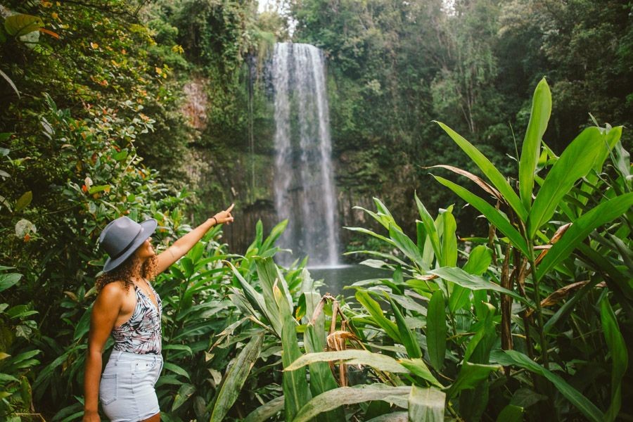 Traveler admiring a waterfall in the rainforest near Cairns