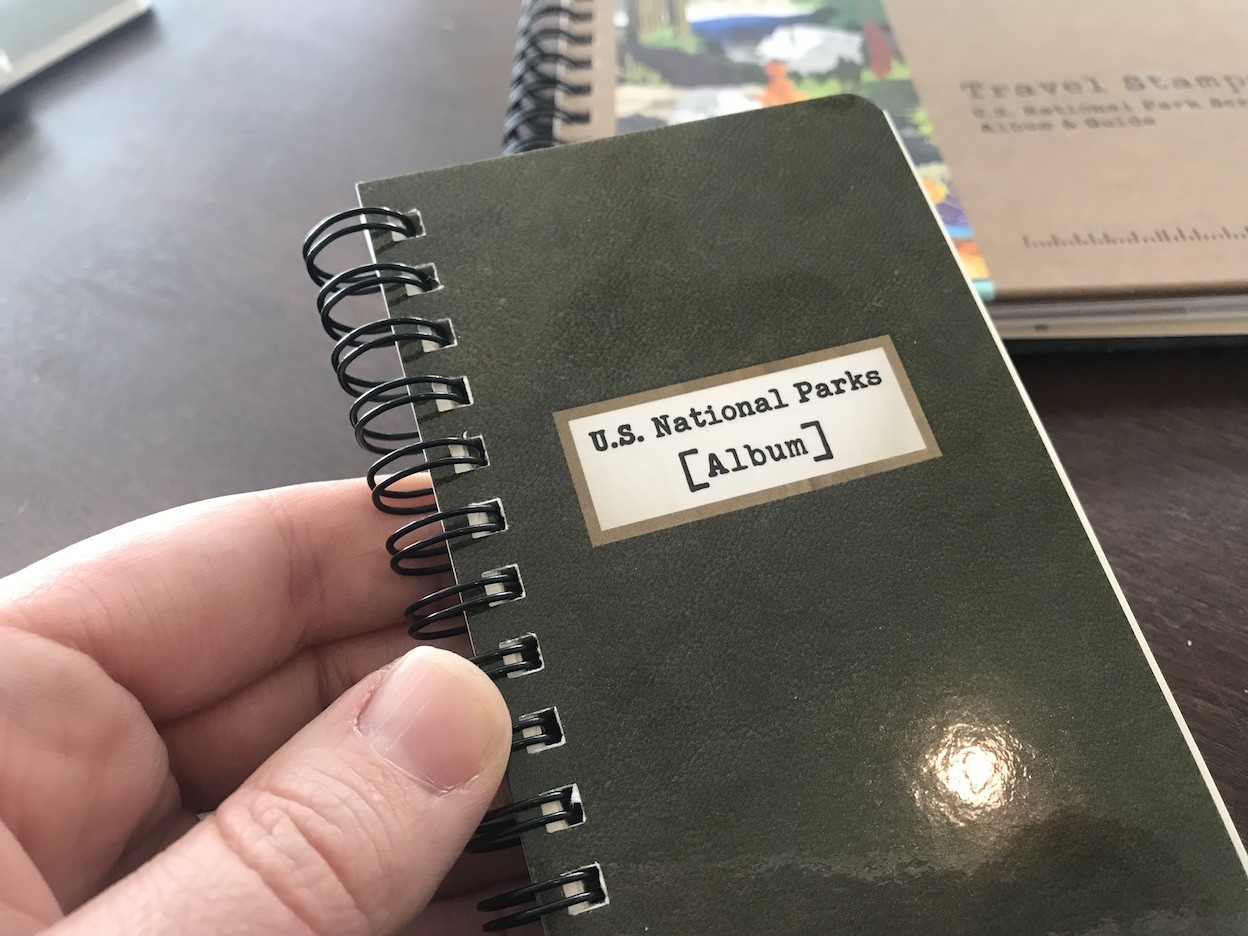 Close-up of a travel stamp album with national park stamps