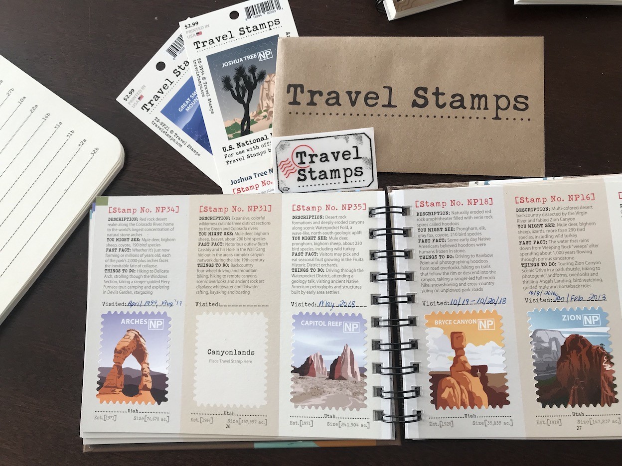Hand placing a travel stamp in a national park album