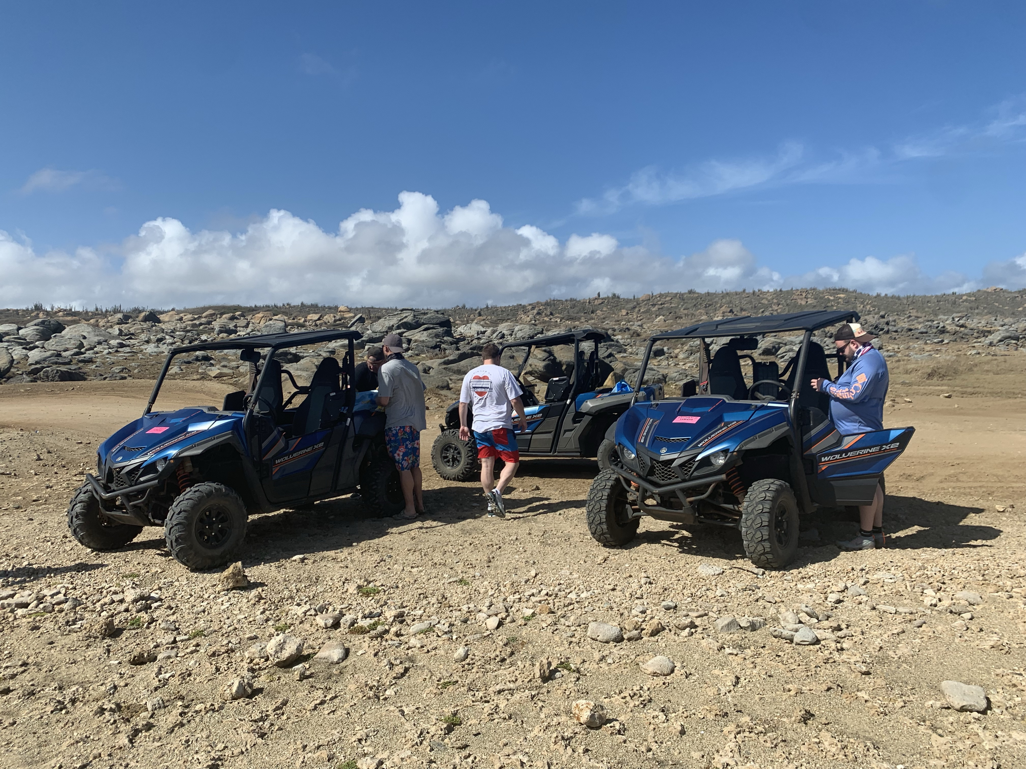 two people riding on a UTV through rocky terrain