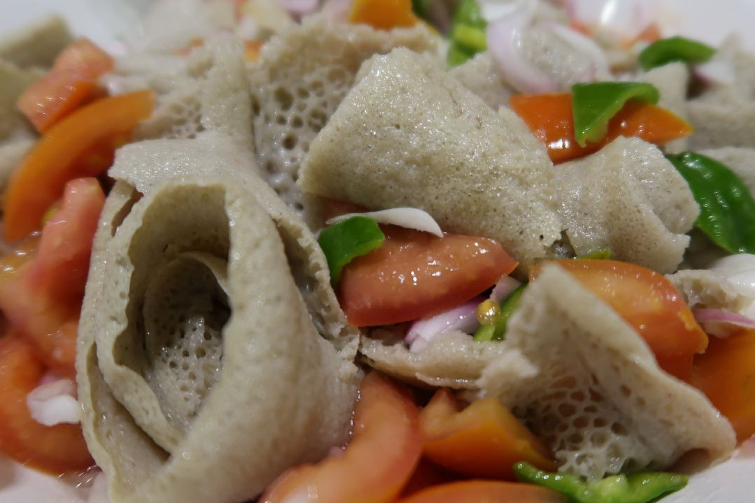 Injera Salad. Traditional Ethiopian cuisine, showcasing the staple injera bread with colorful salad toppings