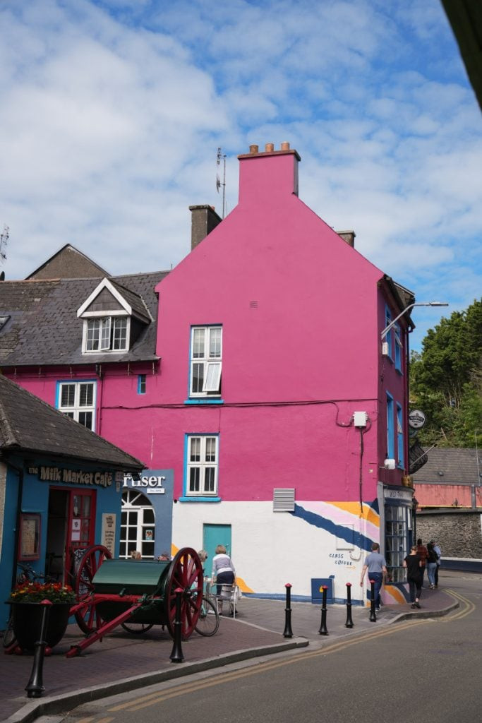 A street in Kinsale with colorful shops and pedestrians