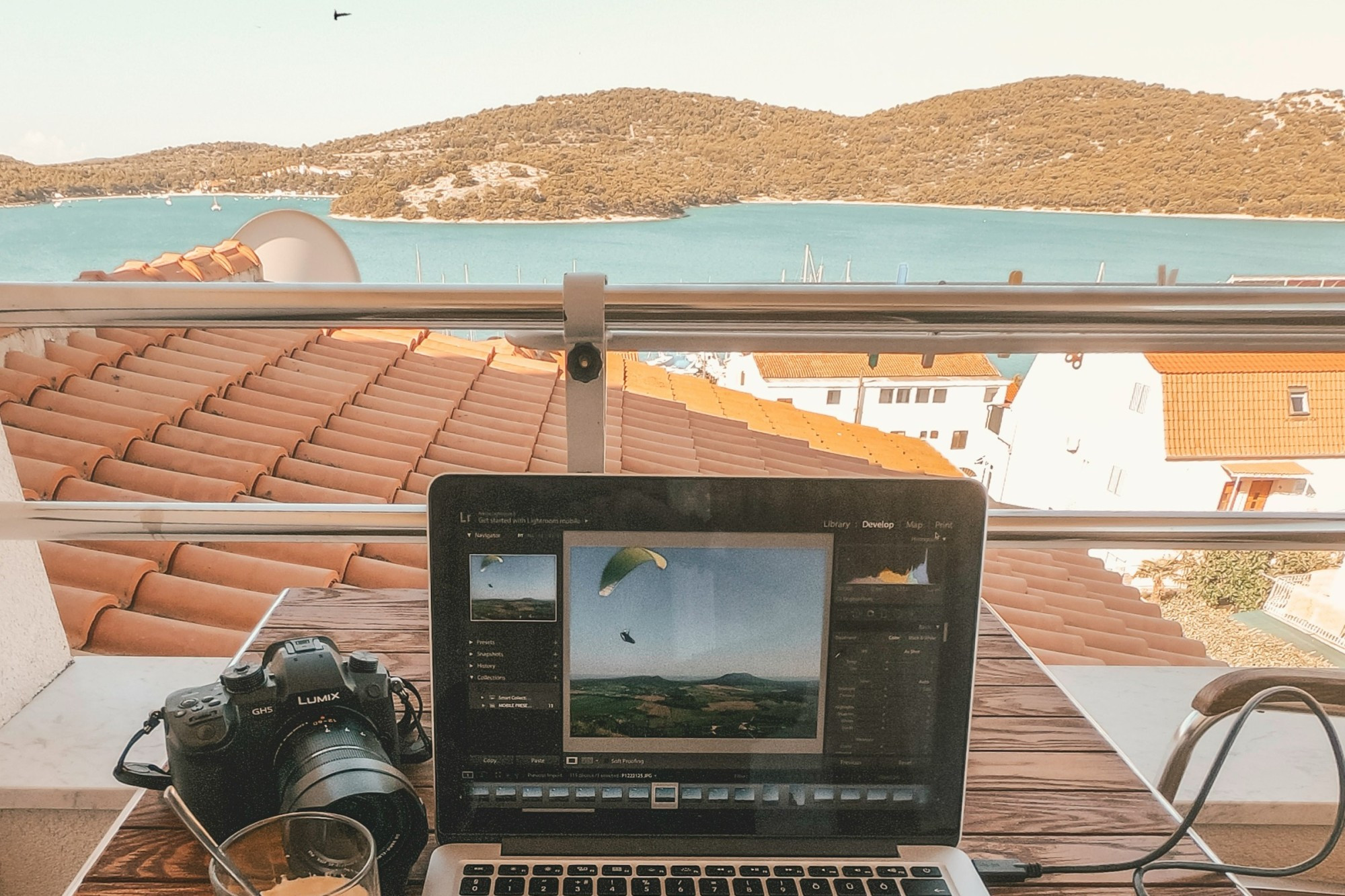 A person working remotely on a laptop, smiling with Vietnam landscape in the background