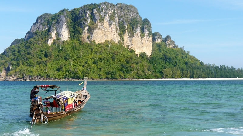 Longtail boat in Krabi, Thailand, with limestone karsts in the background