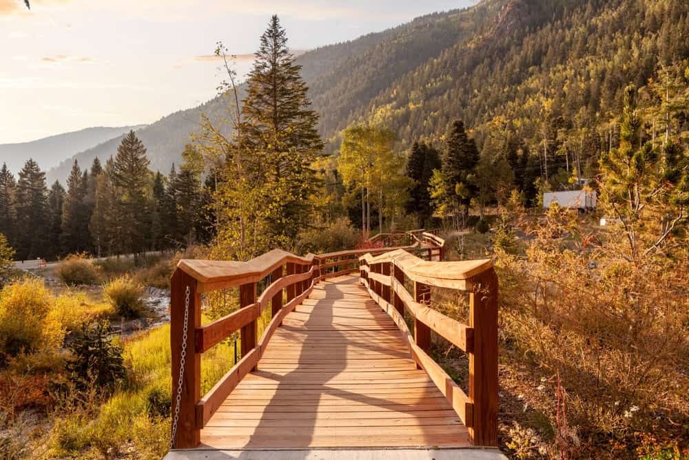 Taos Mountain Trail - Taos Ski Valley - A lake with water and snow near the mountains and green trees