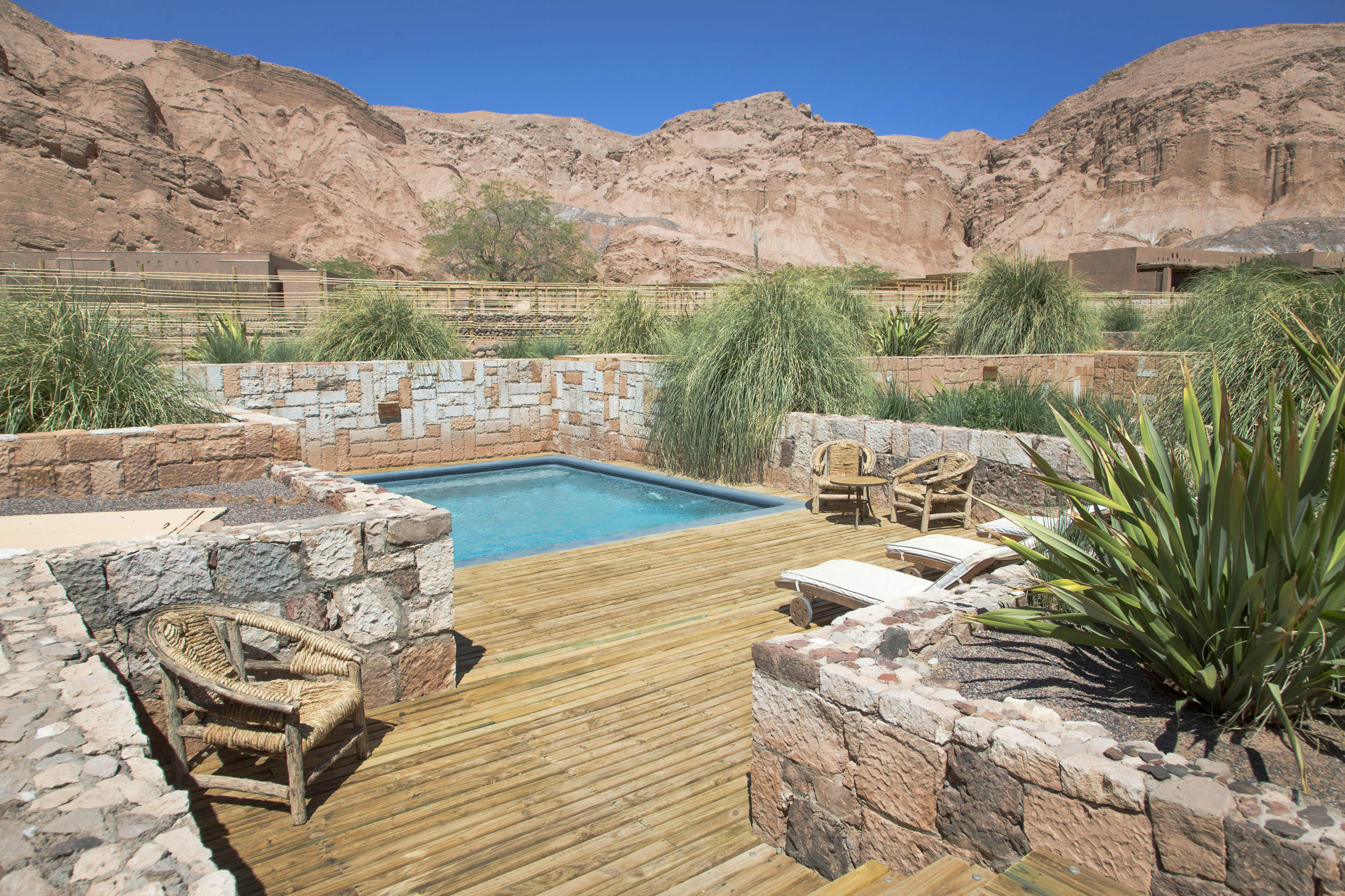 Pool area at Alto Atacama Desert Lodge &amp; Spa with rocky outcrops beyond