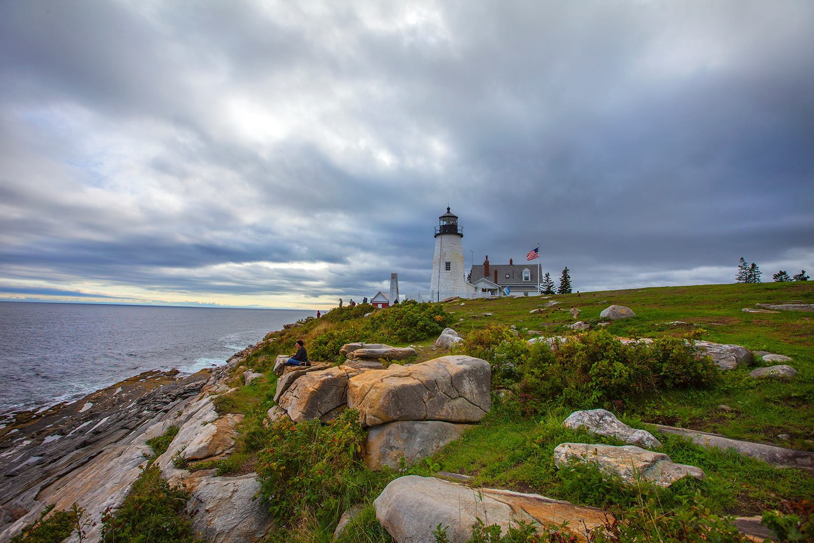 Pemaquid Lighthouse with a scenic rocky coastline and blue sky