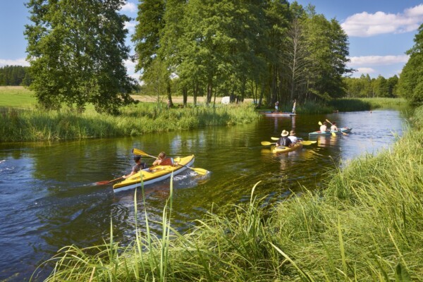 Sailing on the Masurian Lakes, enjoying the beautiful scenery and favorable conditions that attract over 200,000 sailing enthusiasts annually.