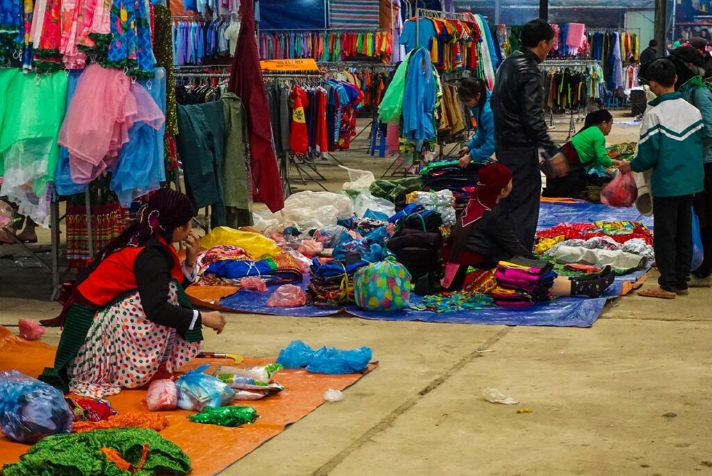 Ethnic people selling colorful clothes at the Meo Vac Market, showcasing the rich cultural heritage and craftsmanship