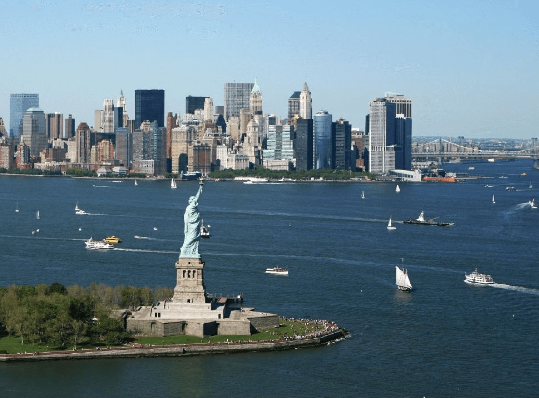 New York City Skyline alt text: The iconic New York City skyline featuring skyscrapers, the Statue of Liberty in the distance, and bustling city streets.