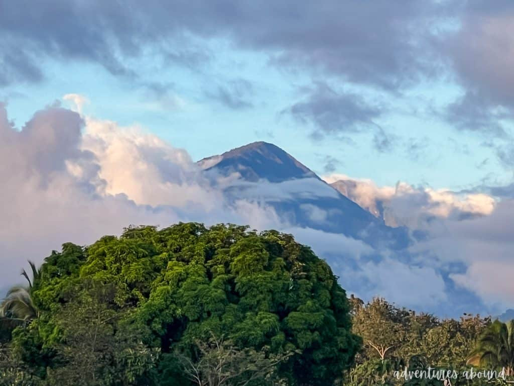 Mountain top coming out of the clouds in front of a tropical woody area in Costa Rica